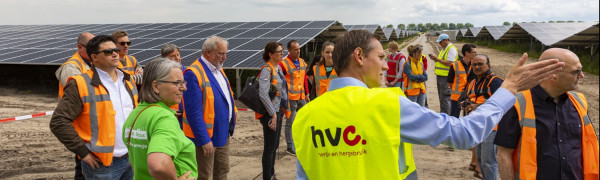 Projectleider staat bij het zonnepark Zuyderzon een geeft bezoekers van de open dag uitleg
