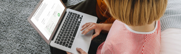 Mevrouw op laptop die de prijs van gas met warmte vergelijkt