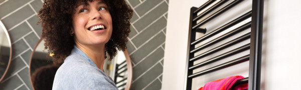 Vrouw hangt handdoek aan radiator