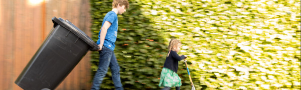 Restafvalbak wordt buiten gezet door jongen