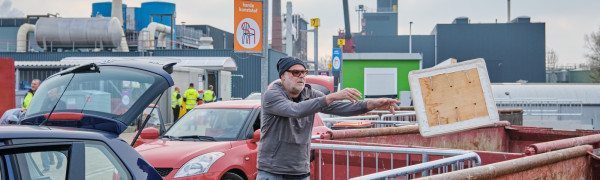 Inwoner gooit afval in container