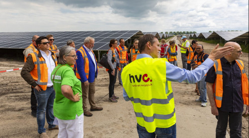 Projectleider staat bij het zonnepark Zuyderzon een geeft bezoekers van de open dag uitleg