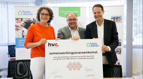 Directeuren Tablis Wonen en HVC en wethouder van de gemeente Sliedrecht houden bord met de tekst samenwerkingsovereenkomst en handtekeningen lachend vast