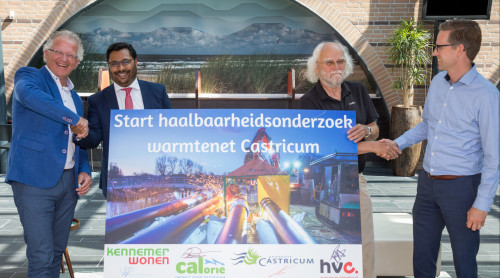 Mannen van KennemerWonen, CALorie, gemeente Castricum en HVC schudden elkaar de hand en houden een bord vast met de tekst Start haalbaarheidsonderzoek warmtenet Castricum