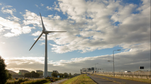 Afbeelding van windmolen Kralingseveer met daarnaast een fietspad en een snelweg.
