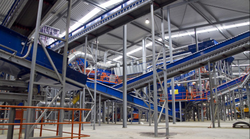 foto van de binnenkant van de sorteer installatie, met verschillende loopbanden en afvalstromen.