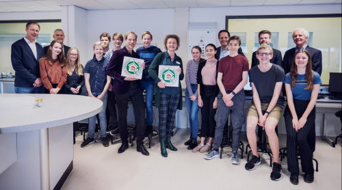 Leerlingen van het PCC in de klas met directeuren en wethouder op de foto
