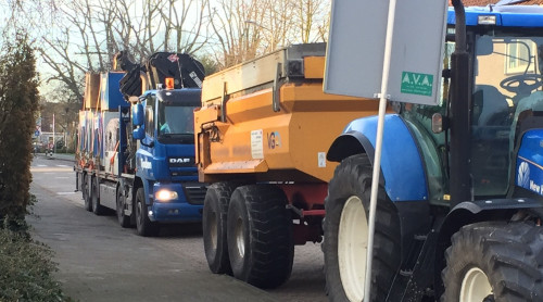 zware werkvoertuigen geparkeerd naast de stoep in een straat.