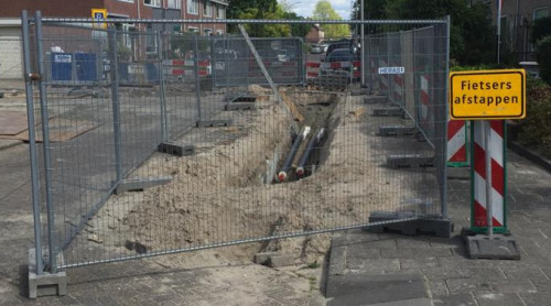 Straat ligt open voor werkzaamheden aan het warmtenet in Sliedrecht - straat is afgezet met hekken en verkeersborden