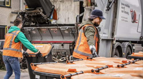 twee beladers helpen bij het legen van de plasticbakken