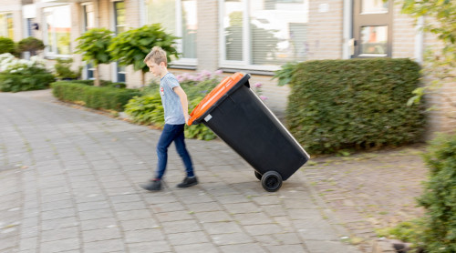 Jongen zet plasticbak aan de weg