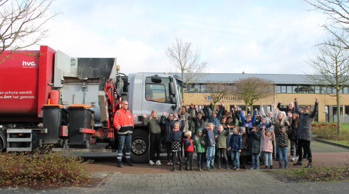 Schoolklas uit Drechterland staat naast de inzamelwagen met chauffeur