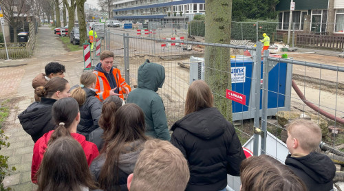 Leerlingen van Het Loket krijgen uitleg van de aannemer over de werkzaamheden voor de aanleg van het warmtenet in Zwijndrecht