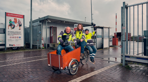 drie medewerkers van het afvalbrengstation rijden op bakfiets naar nieuwe locatie