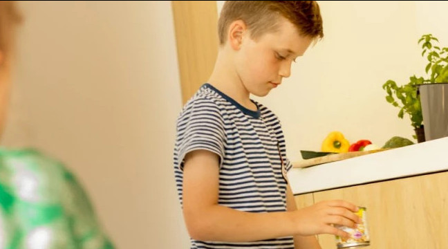 Foto van jongen die twijfelt in welke bak het blikje hoort