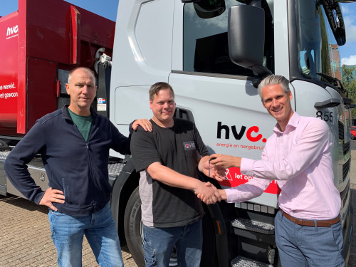 Leverancier overhandigt sleutel aan chauffeur van HVC en geeft hem een hand en teamleider van HVC staat naast chauffeur voor het nieuwe LNG-voertuig