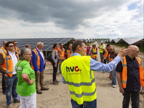 Projectleider staat bij het zonnepark Zuyderzon een geeft bezoekers van de open dag uitleg