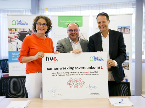 Directeuren Tablis Wonen en HVC en wethouder van de gemeente Sliedrecht houden bord met de tekst samenwerkingsovereenkomst en handtekeningen lachend vast