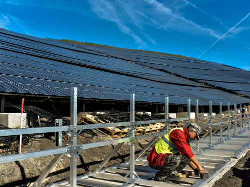 Aanleg van zonnepark Boekermeer in volle gang, werklui monteren de zonnepanelen. 