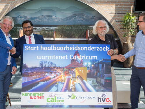 Mannen van KennemerWonen, CALorie, gemeente Castricum en HVC schudden elkaar de hand en houden een bord vast met de tekst Start haalbaarheidsonderzoek warmtenet Castricum