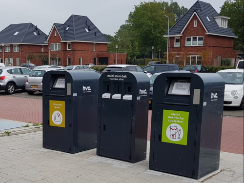 1 multi-minibak voor kleine spullen voor het afvalbrengstation en daarnaast een bak voor frituurvet en een bak voor elektrische apparaten bij parkeerplaatsen bij een supermarkt in
