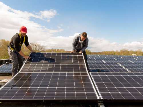 2 mannen installeren zonnepanelen op een dak