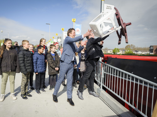 wethouder Arno Janssen en Gertjan de Waard, directeur HVC, gooien een tuinstoel en een kruk in de bak voor harde kunststoffen op het ABS kinderen staan erbij te kijken