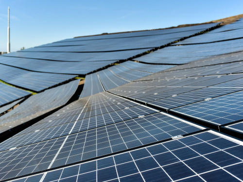 Rij van zonnepanelen tegen een helling.