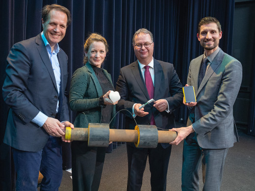 De personen die de intentieverklaring getekend hebben, houden allemaal een voorwerp vast dat wat hen betreft symbool staat voor het warmtenet. HVC: de warmteleiding waardoor de energie geleverd wordt, Poort6: het hart voor de bewoner, maar ook de planeet, Provincie: de deurklink, want in dit proces komen we echt bij mensen achter de voordeur, Gemeente: WakaWaka-lamp, want er zijn ook alternatieve bronnen die je lamp kunnen doen branden zoals zonne-energie.