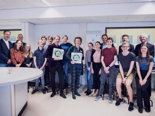 Leerlingen van het PCC in de klas met directeuren en wethouder op de foto