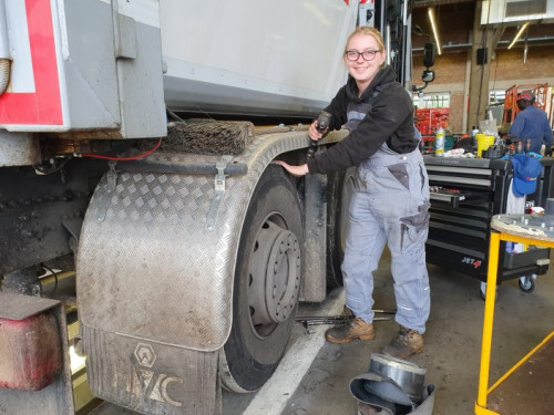 Nikita is bedrijfsautotechnicus. Zij staat bij een wagen van HVC met een schroefmachine in haar rechterhand