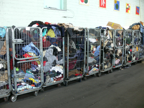 karren vol met ingezameld oud textiel zoals kleding, schoenen, lakens, handdoeken enz.