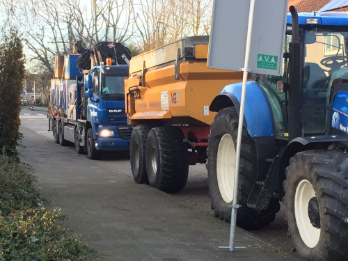 zware werkvoertuigen geparkeerd naast de stoep in een straat.