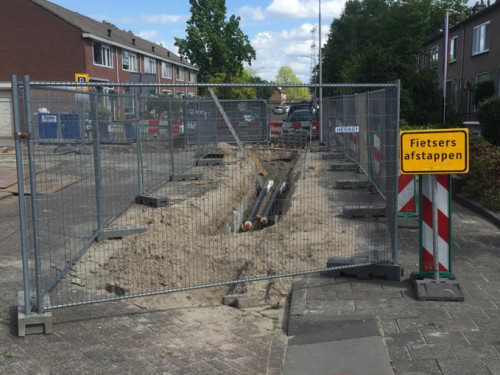 Straat ligt open voor werkzaamheden aan het warmtenet in Sliedrecht - straat is afgezet met hekken en verkeersborden