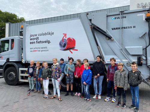 Schoolkinderen uit Bergen staan voor een vrachtwagen van HVC
