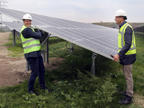 Directeur Ten Elshof en wethouder Van der Linden plaatsen laatste zonnepaneel op het zonnepark Amstelwijck