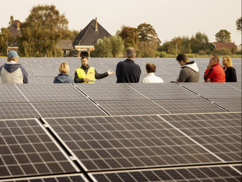 rondleider geeft uitleg aan inwoners bij het zonnepark