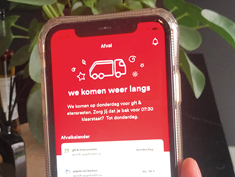 iemand houdt app vast in de keuken