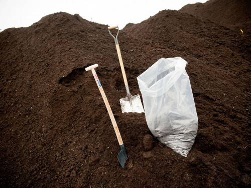 Berg compost met zak en twee scheppen