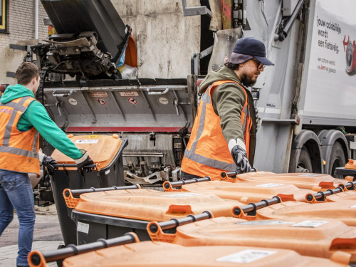 twee beladers helpen bij het legen van de plasticbakken