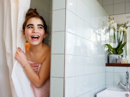 lachend meisje bij douchegordijn