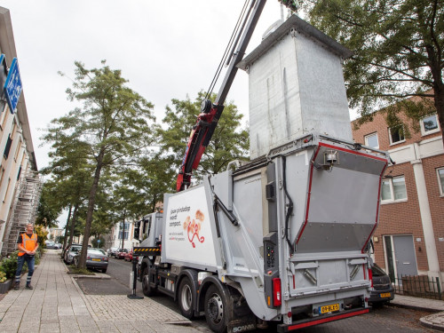 chauffeur leegt een ondergrondse container in de vrachtwagen