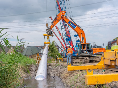 warmtepijp gaat onder de grond met hulp van kranen