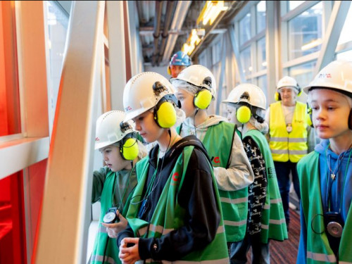 groep kinderen met helmen op kijken door het raam