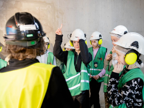 Louise op de rug met kinderen om haar heen met helm op