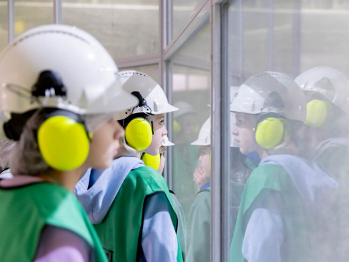 2 kinderen van dichtbij kijken door glas. Je ziet hun weerspiegeling